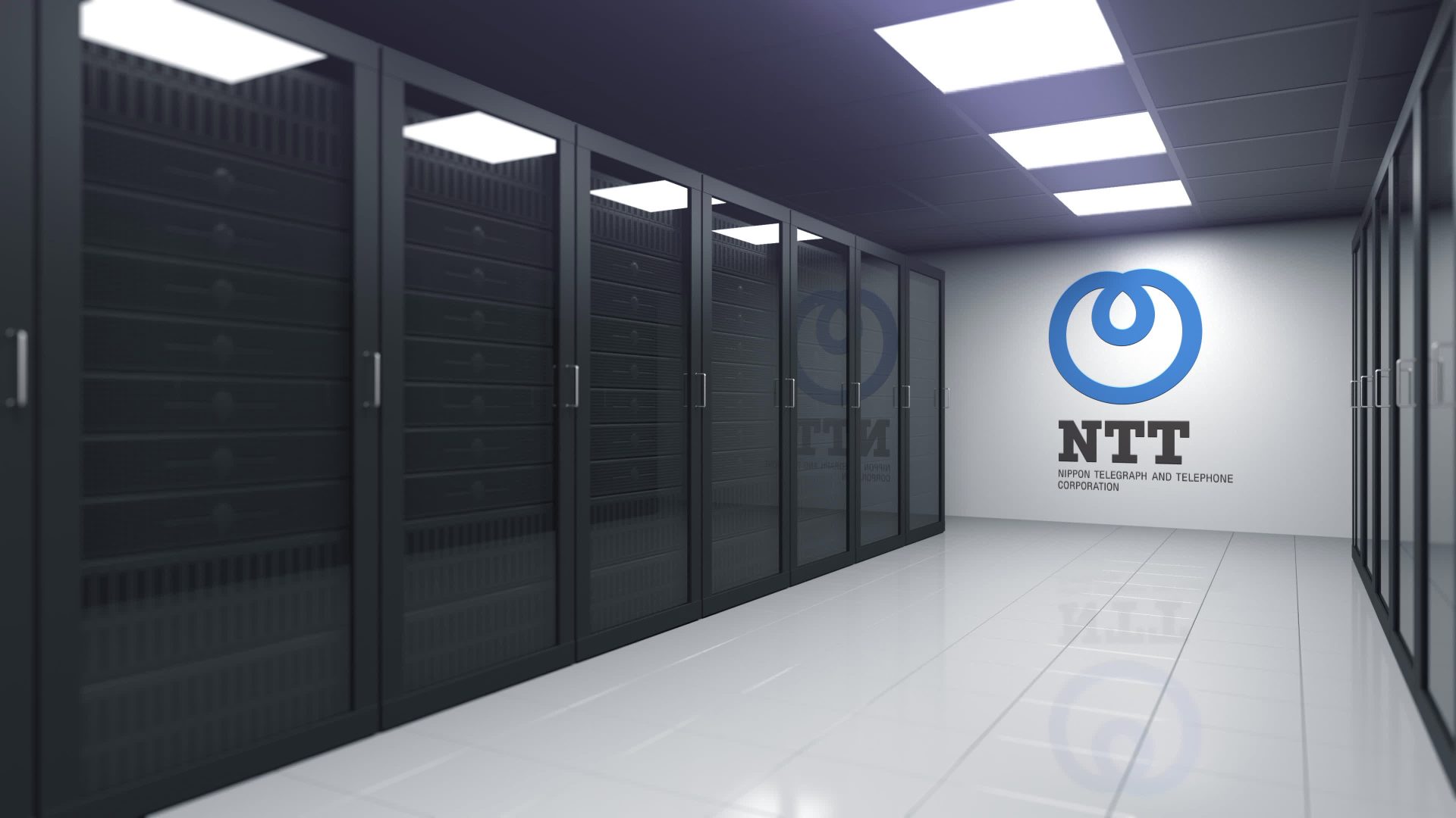 Modern data center interior featuring rows of black server racks and a large NTT (Nippon Telegraph and Telephone Corporation) logo on a white wall.